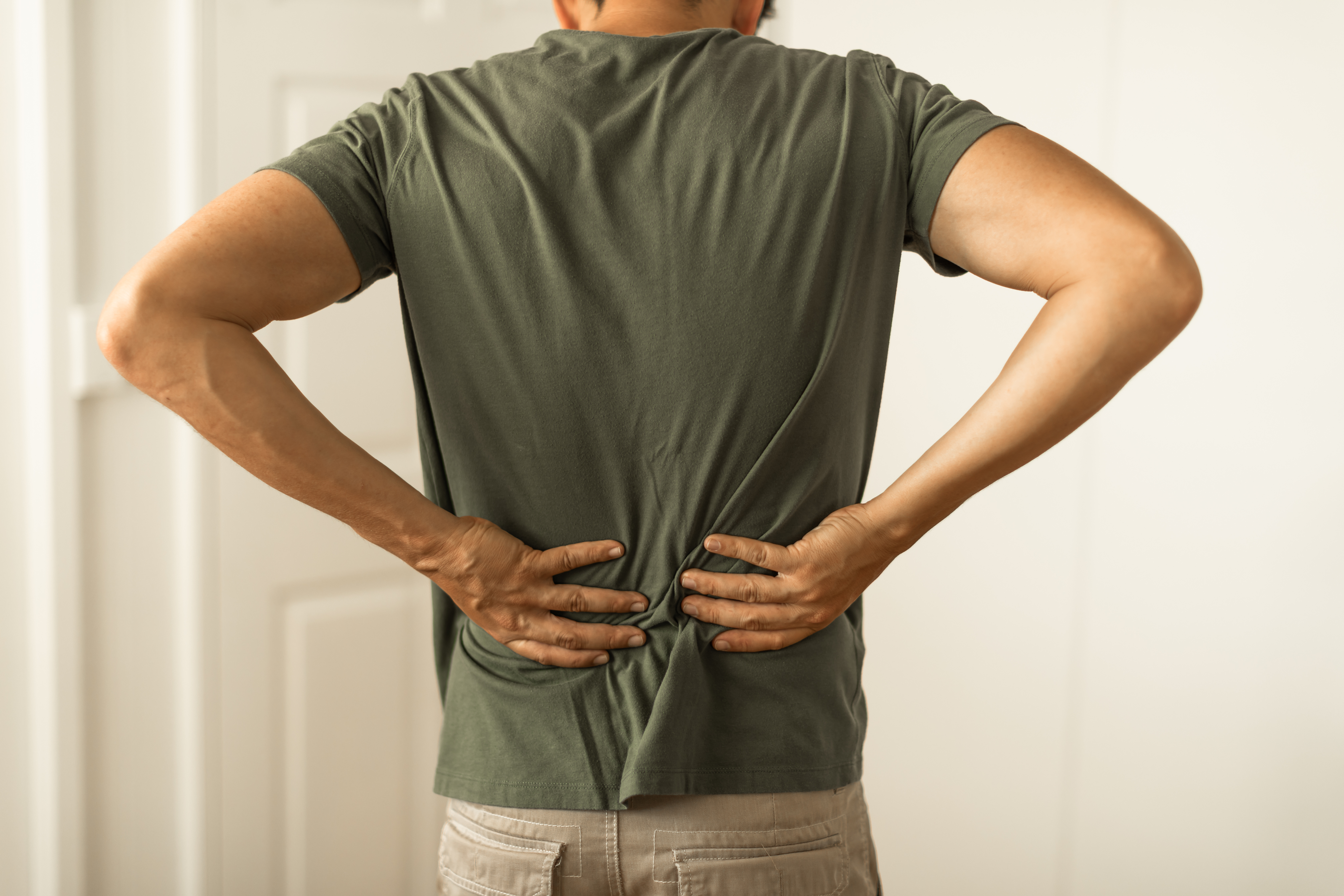 Person gently holding their lower back